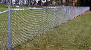 This is an image of a chain link fence.  This is a metal fence with a basket-weave pattern of metal wires.